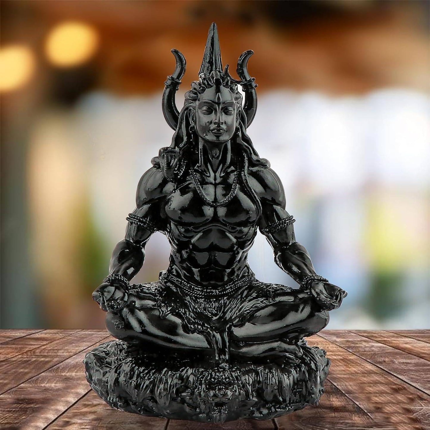 Glossy black Adiyogi Meditation Statue on wooden surface, ideal for table decor or spiritual sculpture collection in home settings.