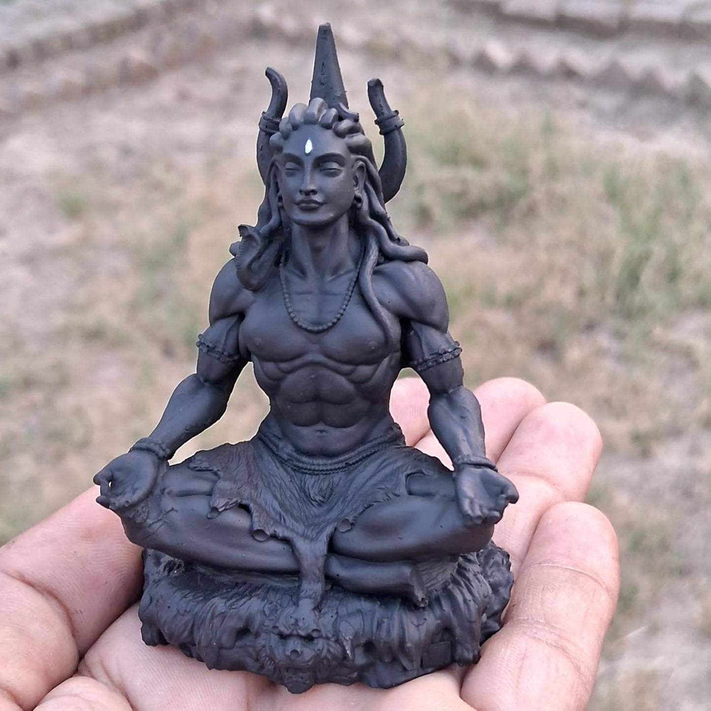 Close-up of Adiyogi Meditation Statue in hand, highlighting fine craftsmanship and compact size for home or car dashboard use.